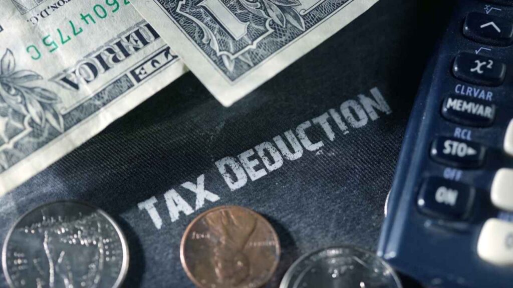 Tax deductions calculator with dollar bills and coins