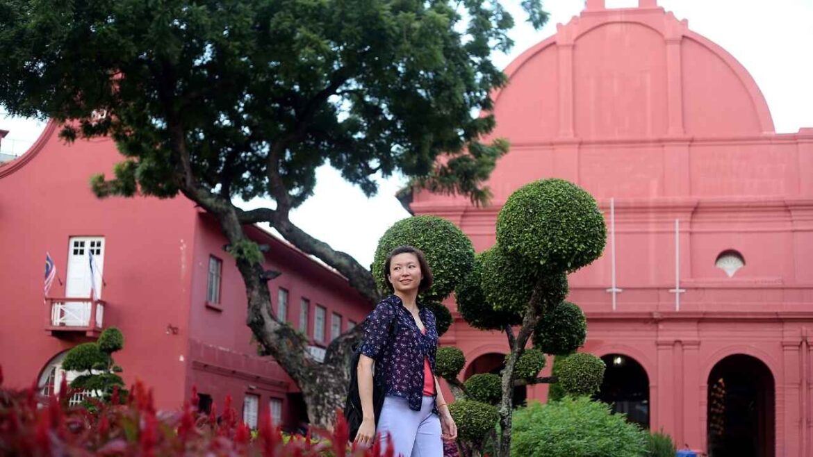 Woman exploring pink colonial architecture to travel like a local in historic district