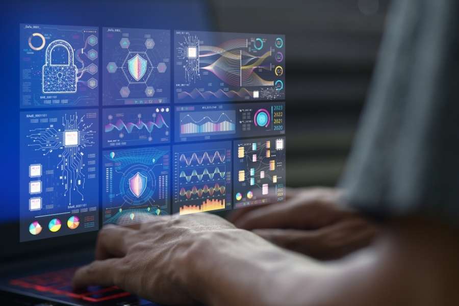 A person using a laptop with futuristic holographic AI data analytics tools showing security icons and charts.